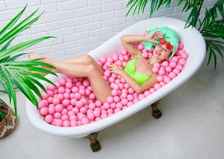the woman is lying down in a bath filled with balls