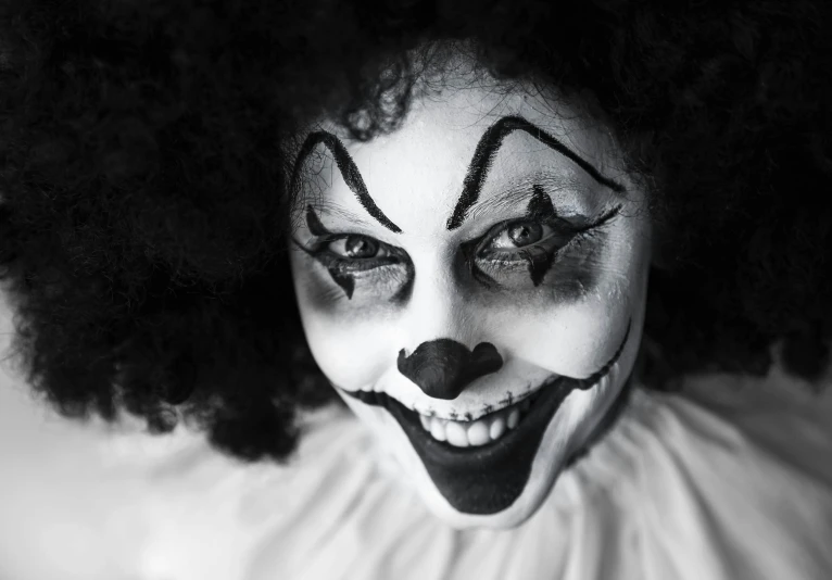 woman in black and white clown makeup and curly hair
