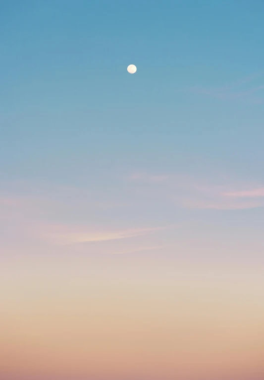 two people with surfboards standing on the beach at dusk