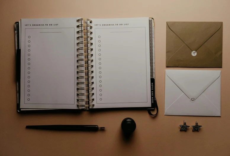 an open planner next to some office supplies