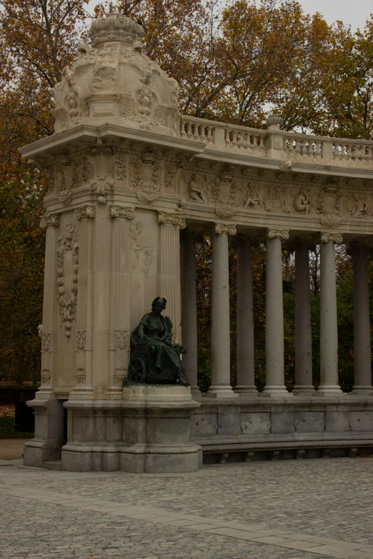 the building has many pillars around it with two statues