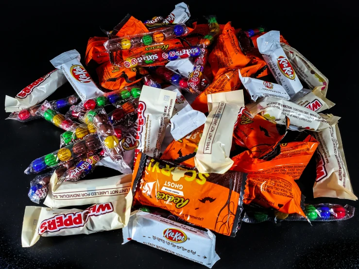 a pile of candy and candies on a black surface