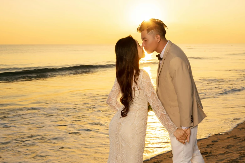 a man kissing a woman on the beach at sunset