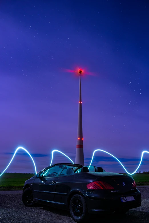 car parked in lot near two tall lightening poles