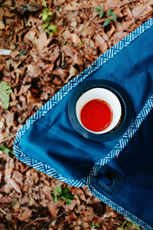 cup of tomato sauce in a white bowl on a blue cloth with a napkin