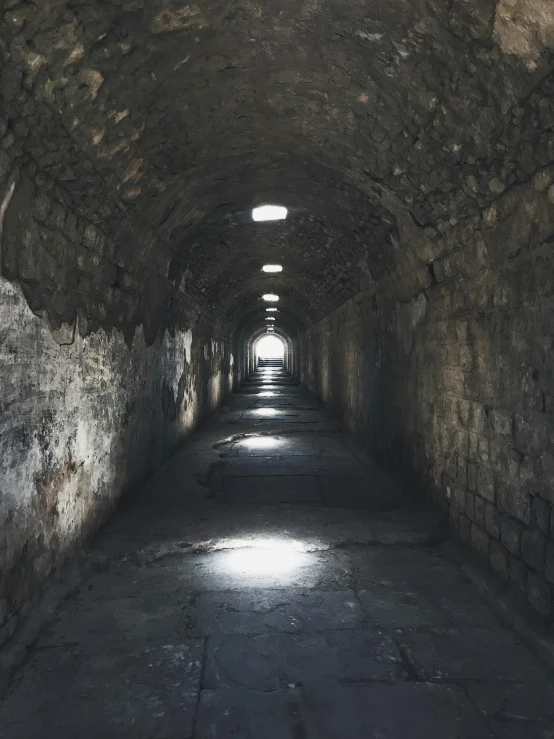 a tunnel has a lot of stone on the walls