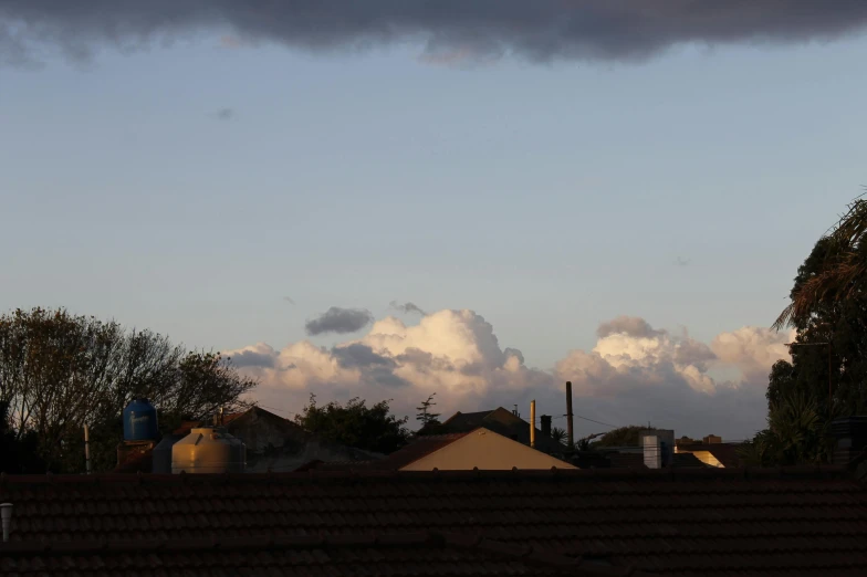 a view of houses against a cloudy blue sky