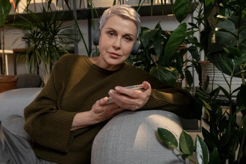 a woman sitting on a sofa looking at her cell phone