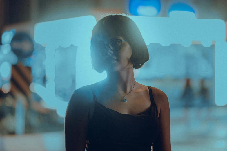 a woman standing in a dark hallway wearing a black dress