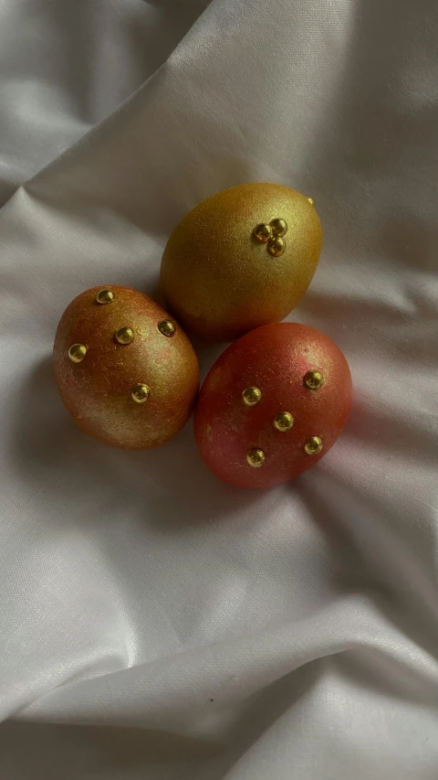 three tomatoes are sitting in close - up against the fabric