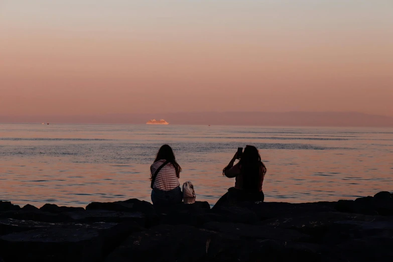 two girls are looking out at the water