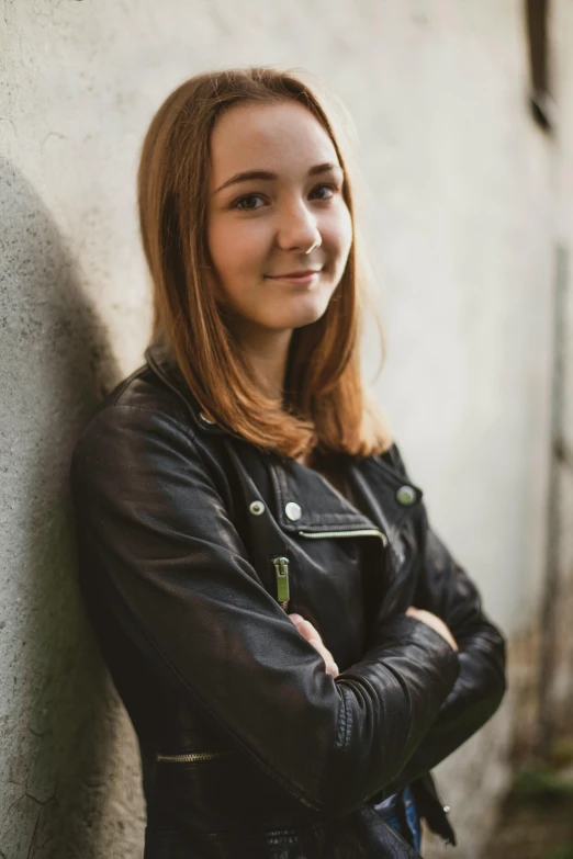 a woman is leaning against a wall