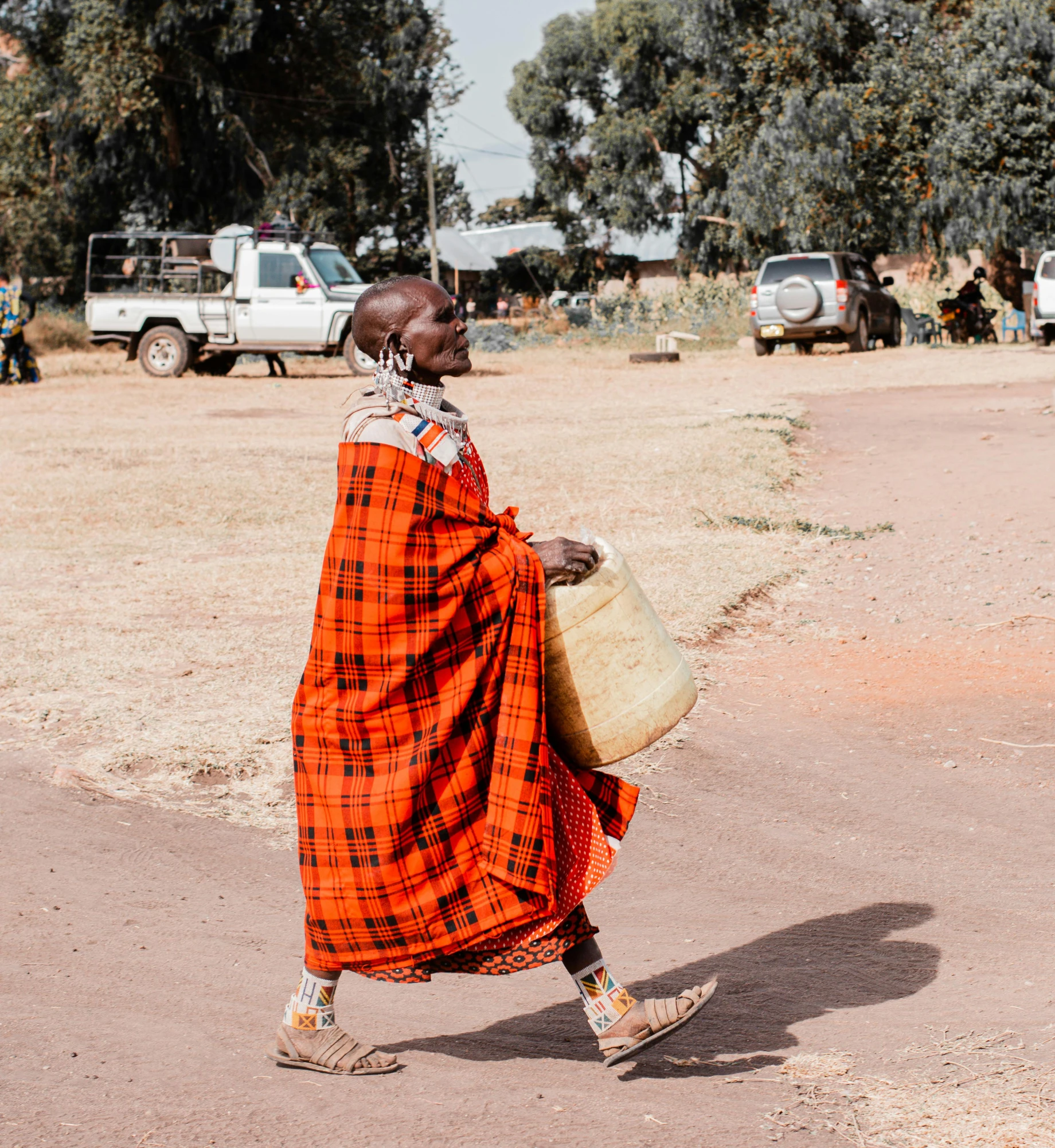 a woman with an orange plaid robe carrying soing in her hand