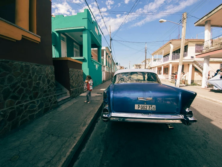 a blue car parked along the side of a road