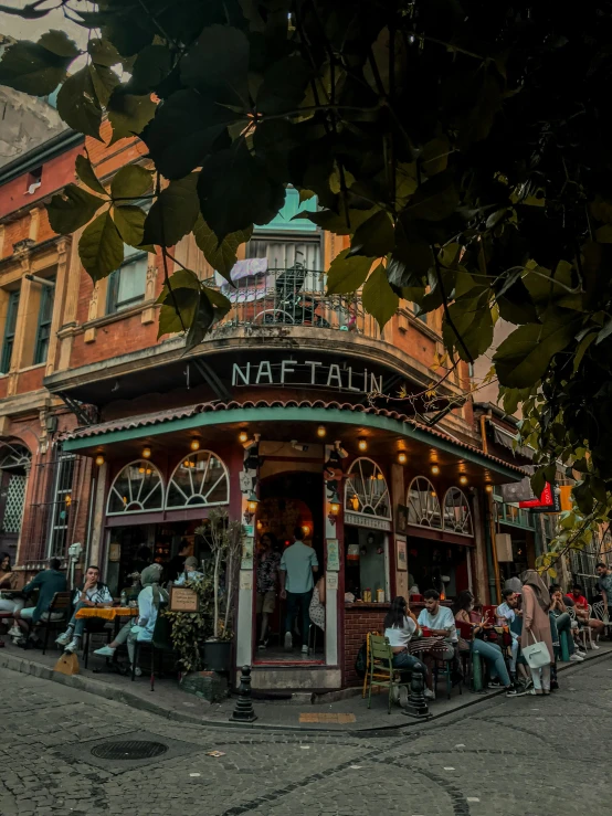 people outside a small cafe in a historic european city