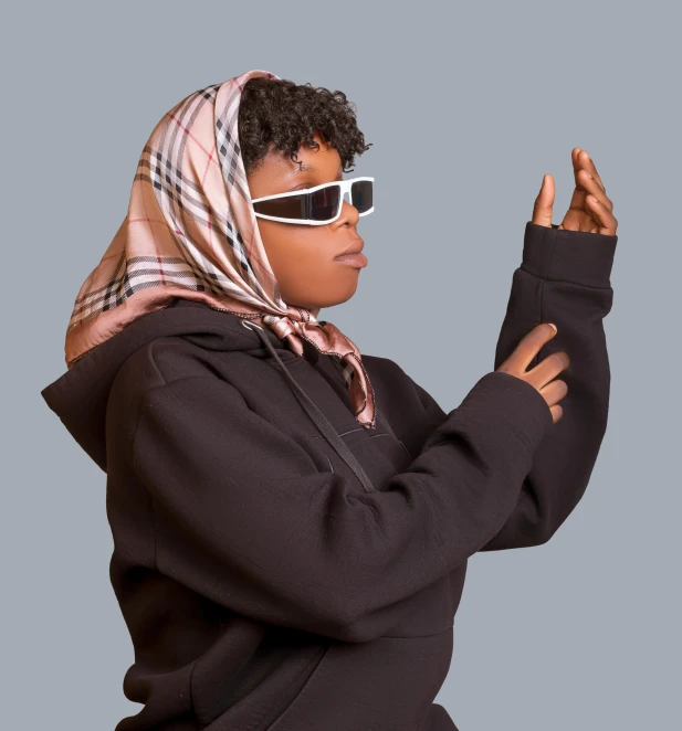 a woman with sunglasses, a hooded sweatshirt and a scarf