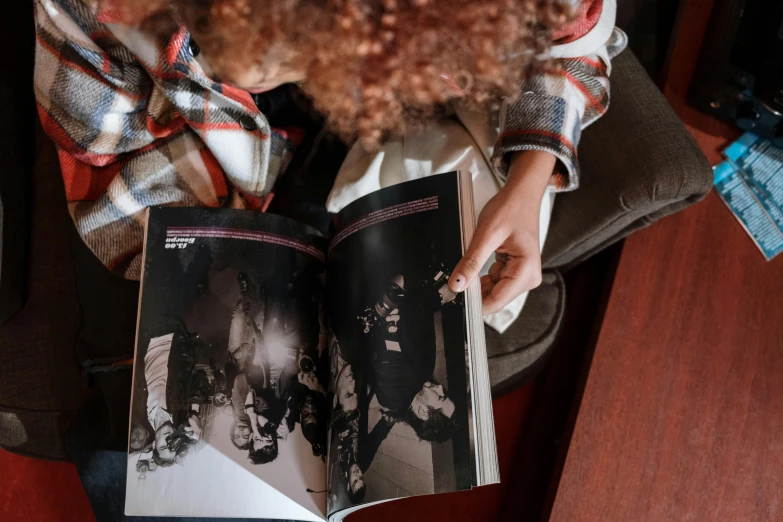 a person with a weird hairy hair on their head is holding some books