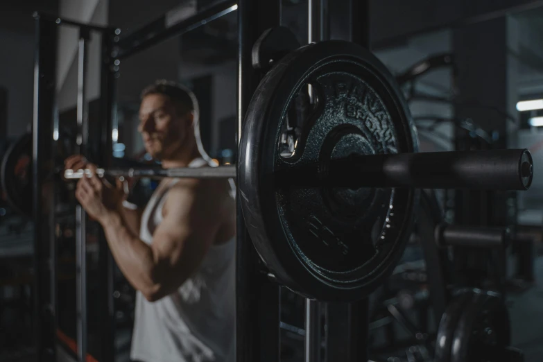 a man is in the gym with barbells