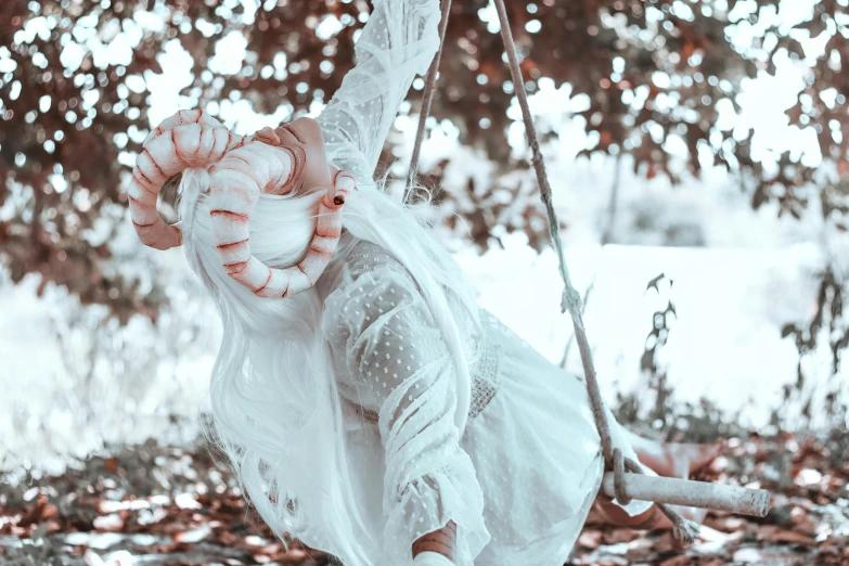 the girl in a white dress rides on a swing