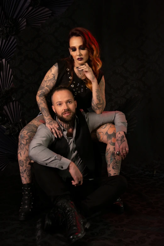 a man holding a woman and one with tattoos on her arms