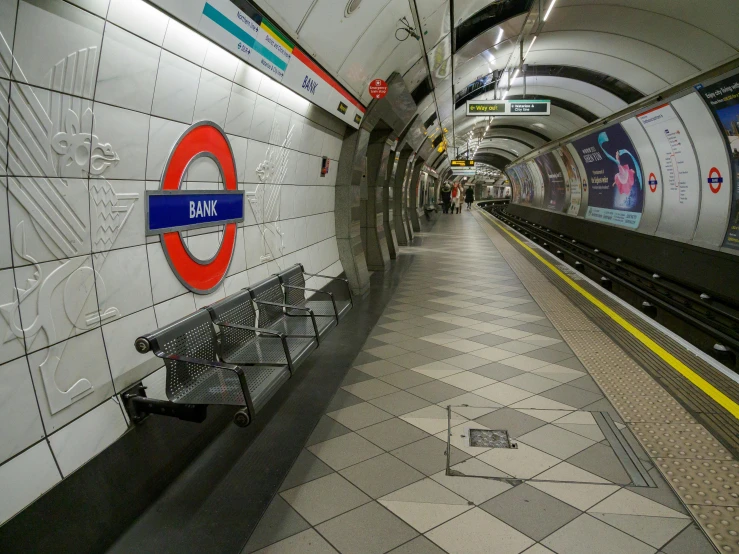 this is an underground platform with benches and subway signs on it