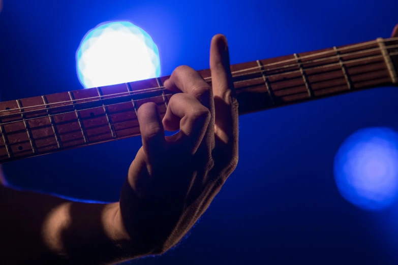 a person is holding up an acoustic guitar in the dark