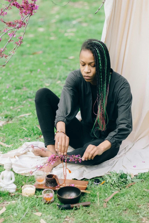 a young woman is sitting outside while painting