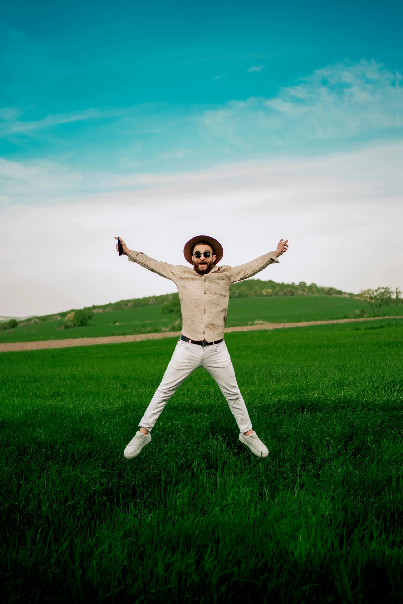 a man standing in the grass with his arms outstretched