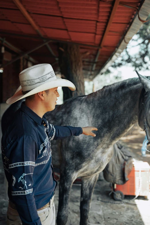 a man stands with a horse and pet it