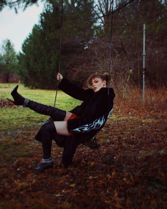 a girl sitting on a chair swinging on her own strings