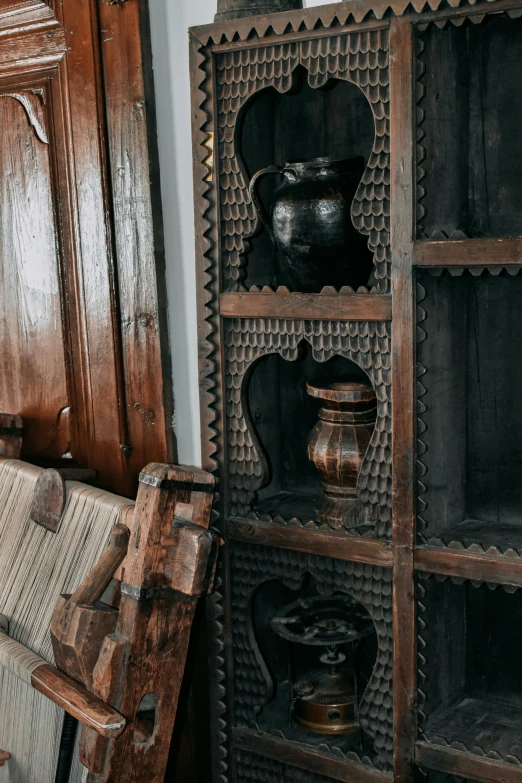 an old wooden chair and bookshelf with decorative carvings on them