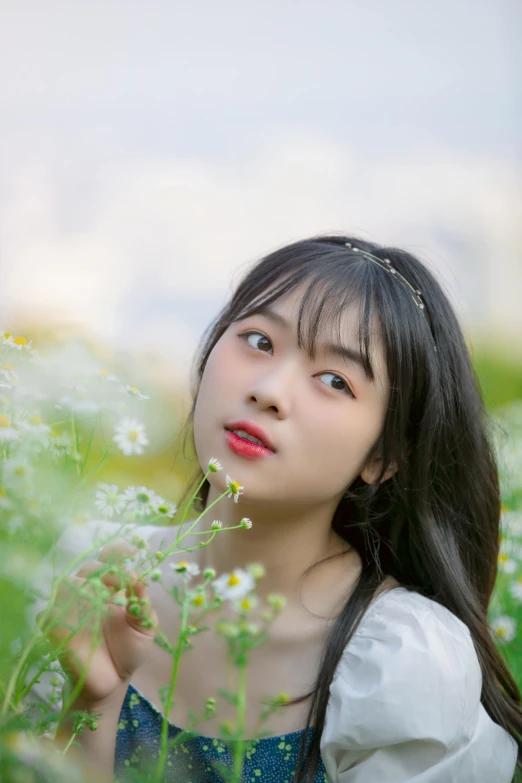 the young asian girl is posing in a field