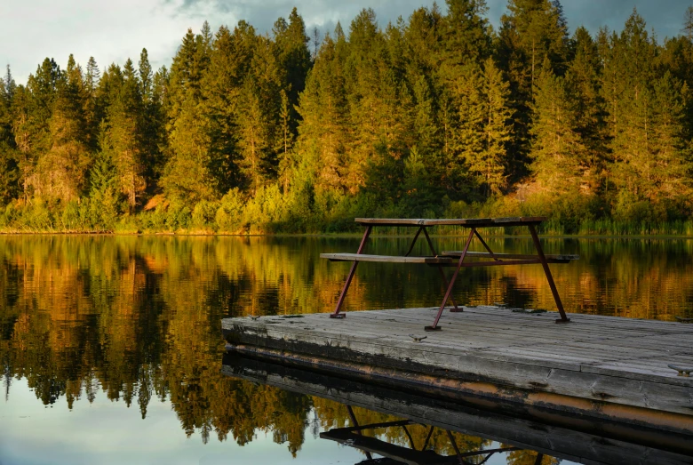 an outdoor wooden dock sitting in front of a lake