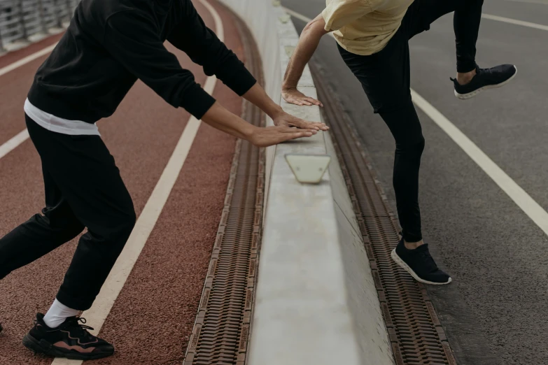 people playing with sand on a road with one woman reaching for the hand of another person