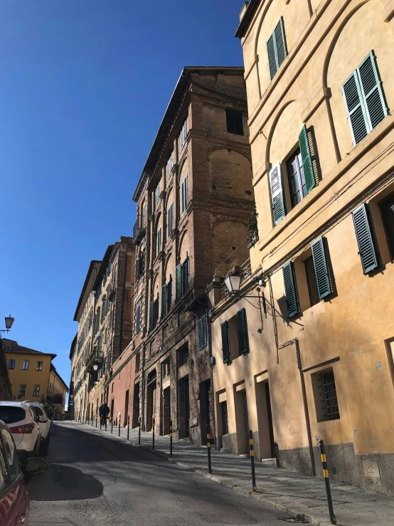 a quiet street next to an alley with lots of tall buildings