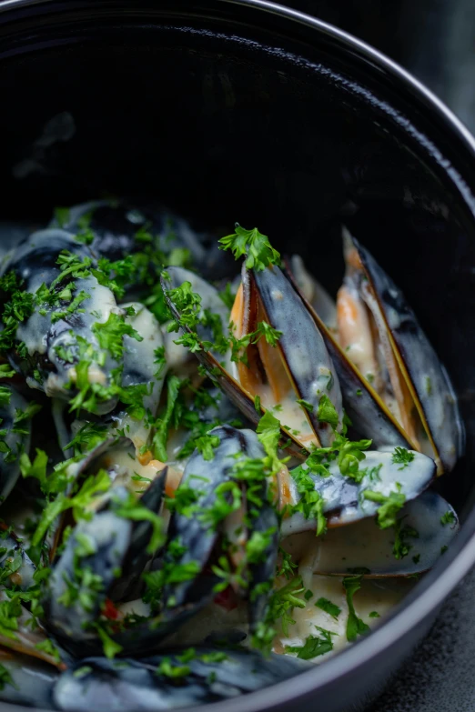 a bowl of food containing mussels and parsley