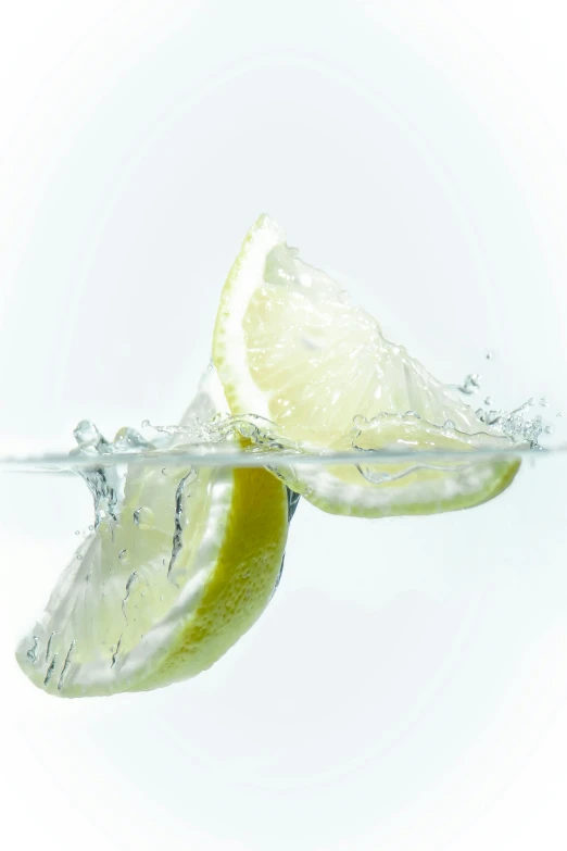 a lime slice in the water with a splash