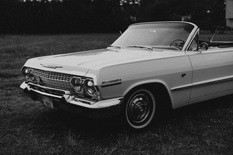 the front view of a white ford convertible parked in a grassy field