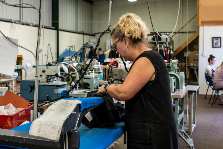 there is a woman at a factory making bags
