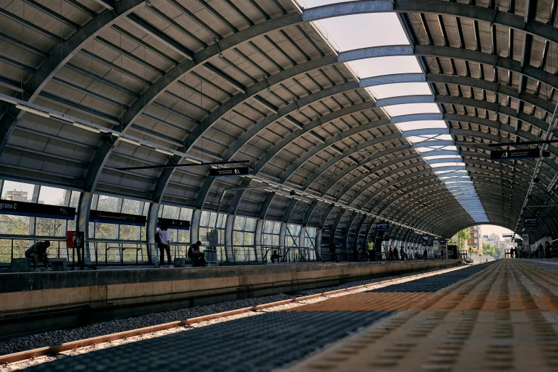 an empty train station platform with people walking around