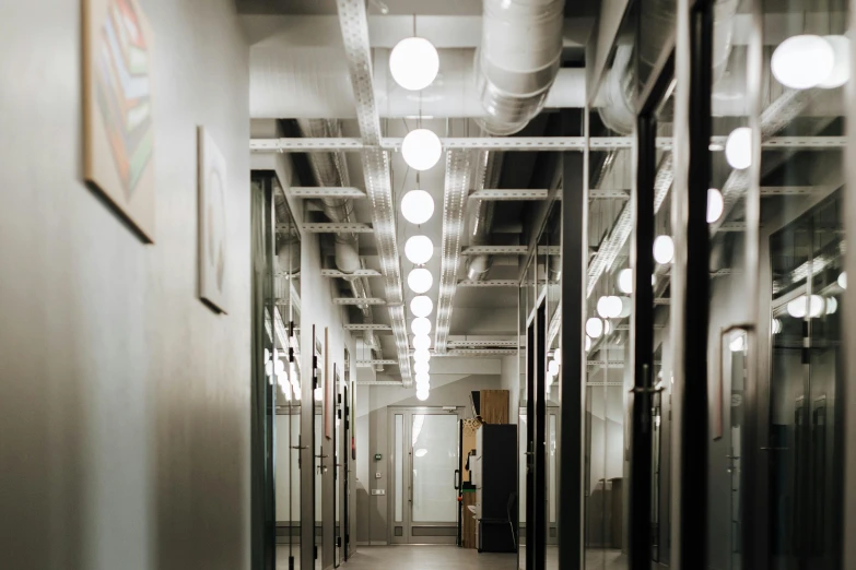 an empty hallway that has lots of mirrors and lights on it