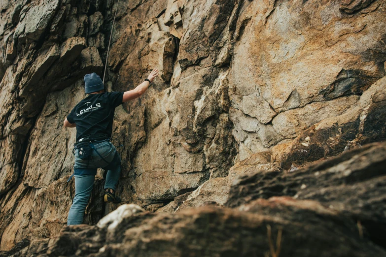 a man is climbing up on a rocky ledge