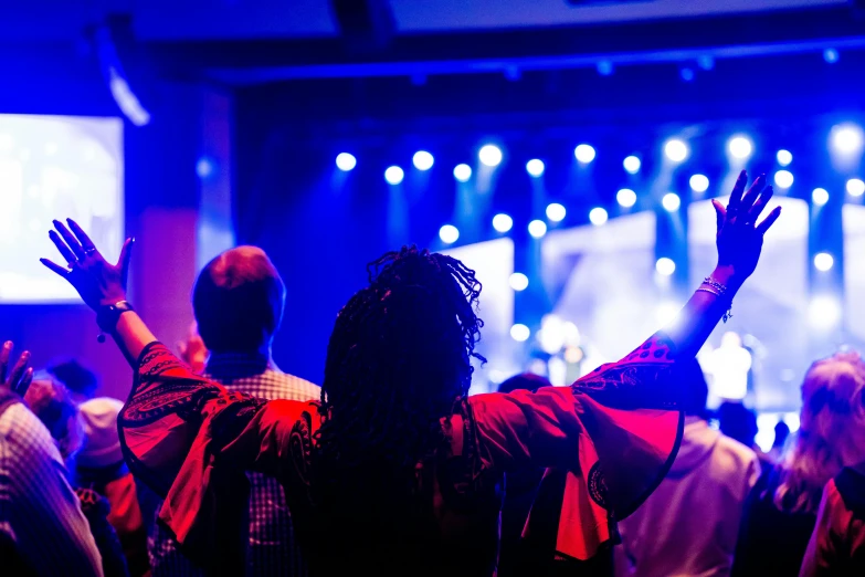 silhouettes of people in front of the screen as they dance at an event