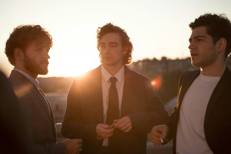 three men standing outside talking and laughing