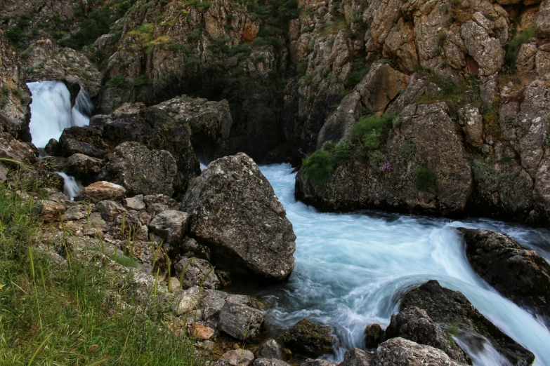 the water comes out of the rocks next to the mountain