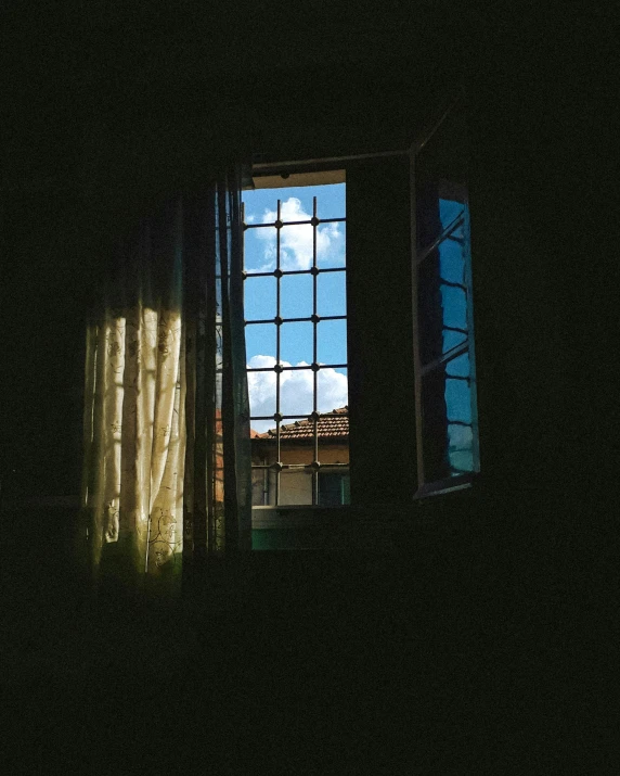 a window with the curtains closed and a sky seen through it