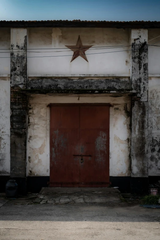 a brown door in a white building with a big star on it