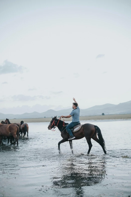 a man riding a horse across a body of water