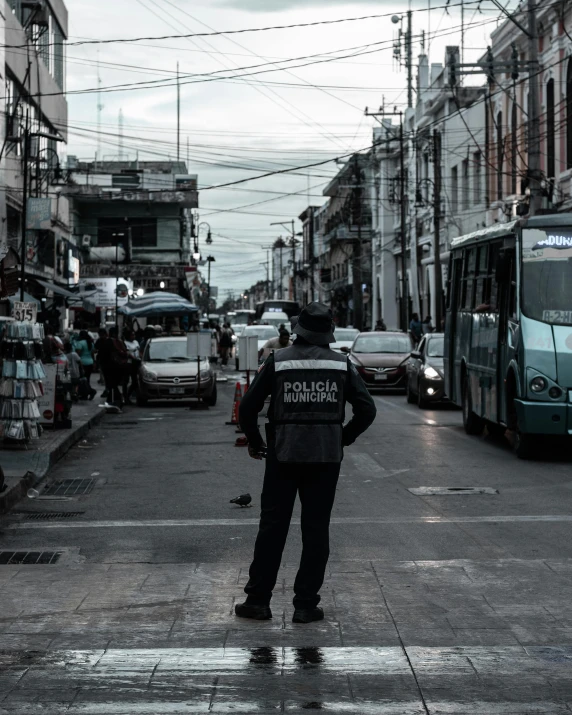 man standing in the middle of road with vehicle coming towards him