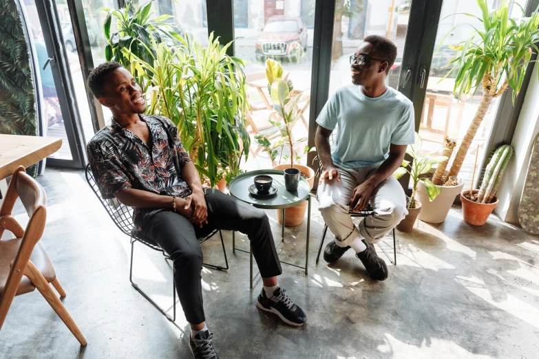 two men are sitting and talking at tables